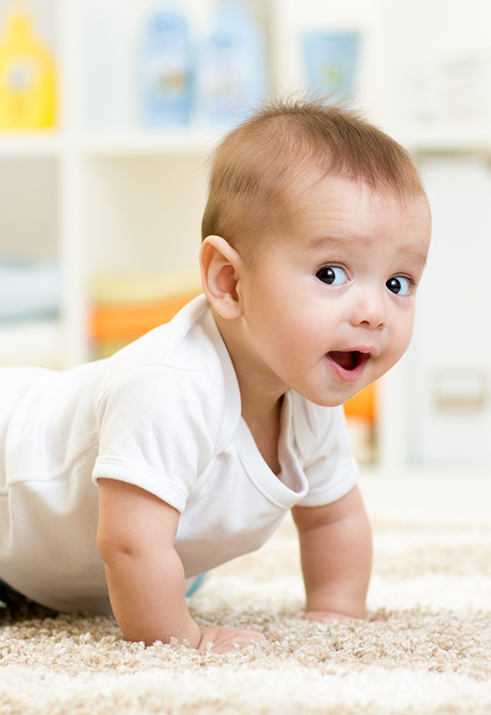 Child crawling across a white carpet